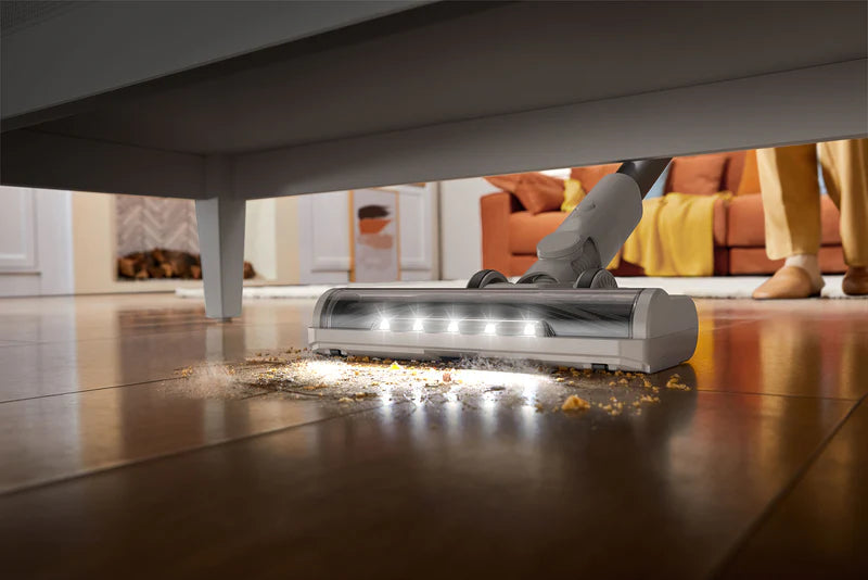Dreame vacuum cleaner with LED lights cleaning dust and debris under furniture