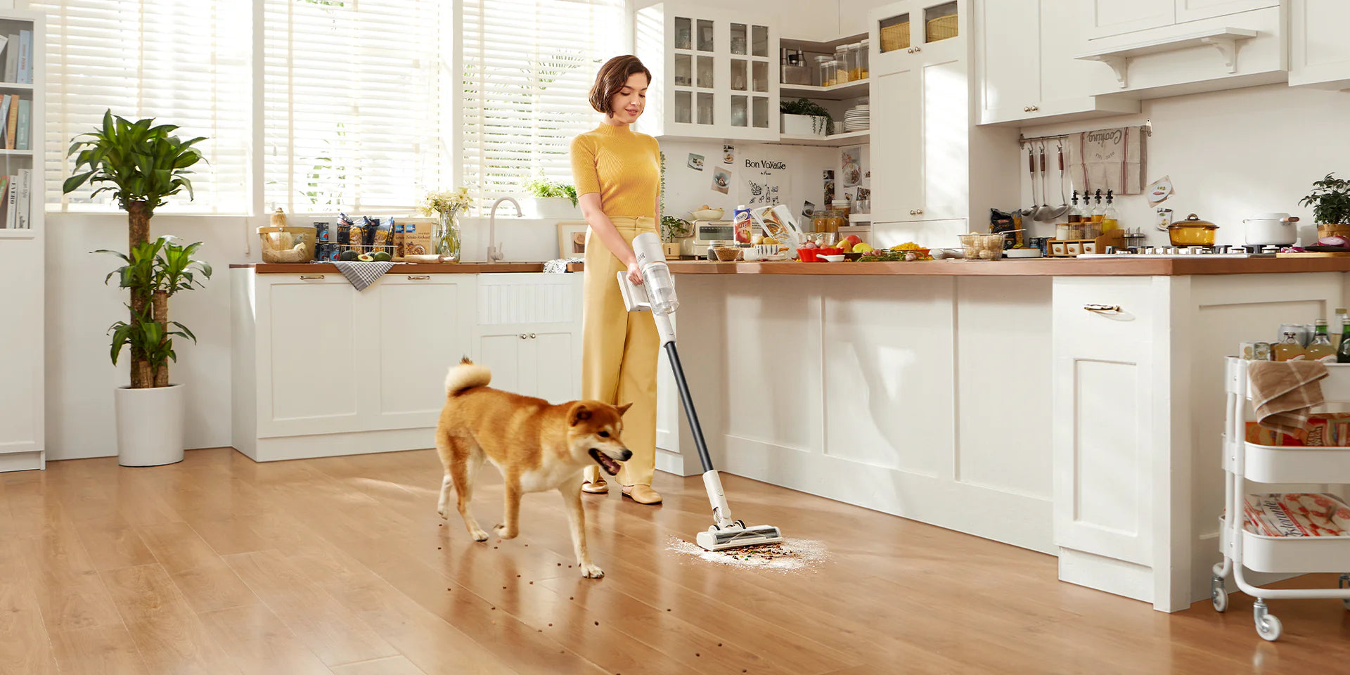 Woman using Dreame U10 cordless vacuum in kitchen